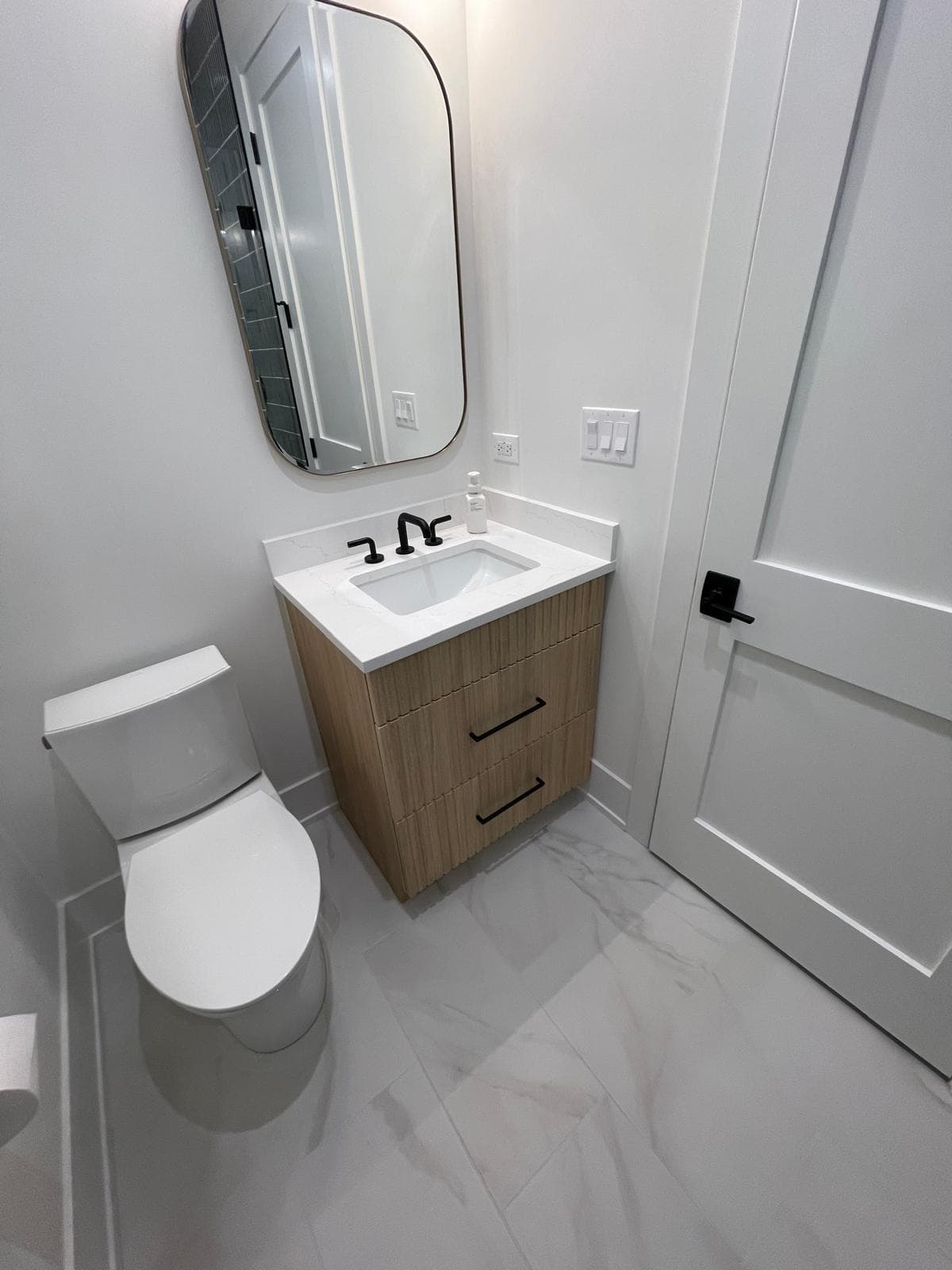 Modern powder room with statement wallcovering and floating vanity — custom home detail