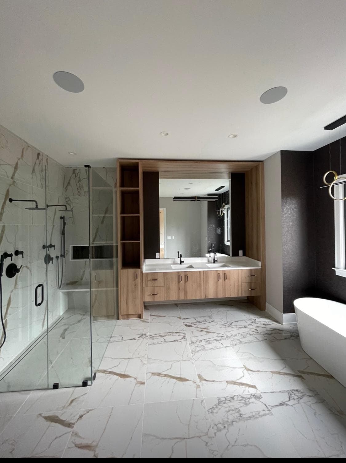 Panoramic view of luxury master bath featuring dual vanities, soaking tub, and natural stone