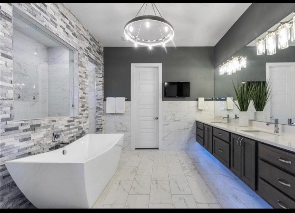 Freestanding soaking tub with crystal chandelier — spa master bath renovation by Epic Homes