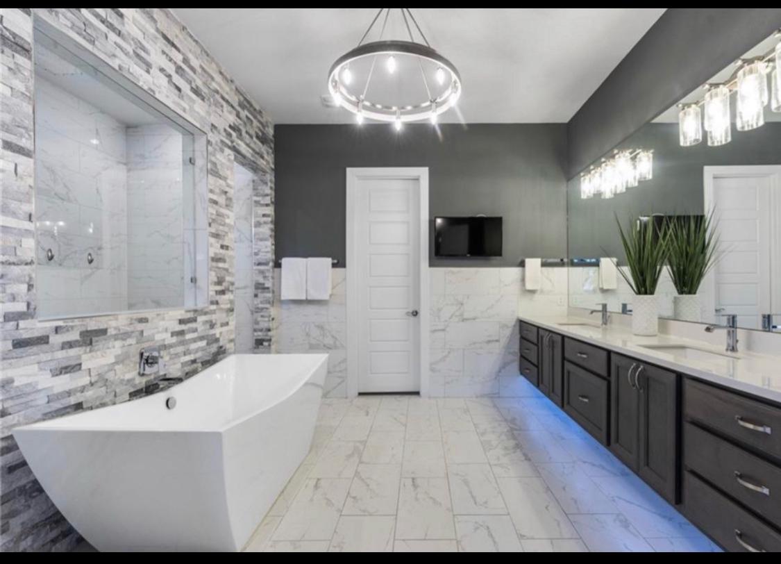 Luxury freestanding soaking tub beneath a crystal chandelier