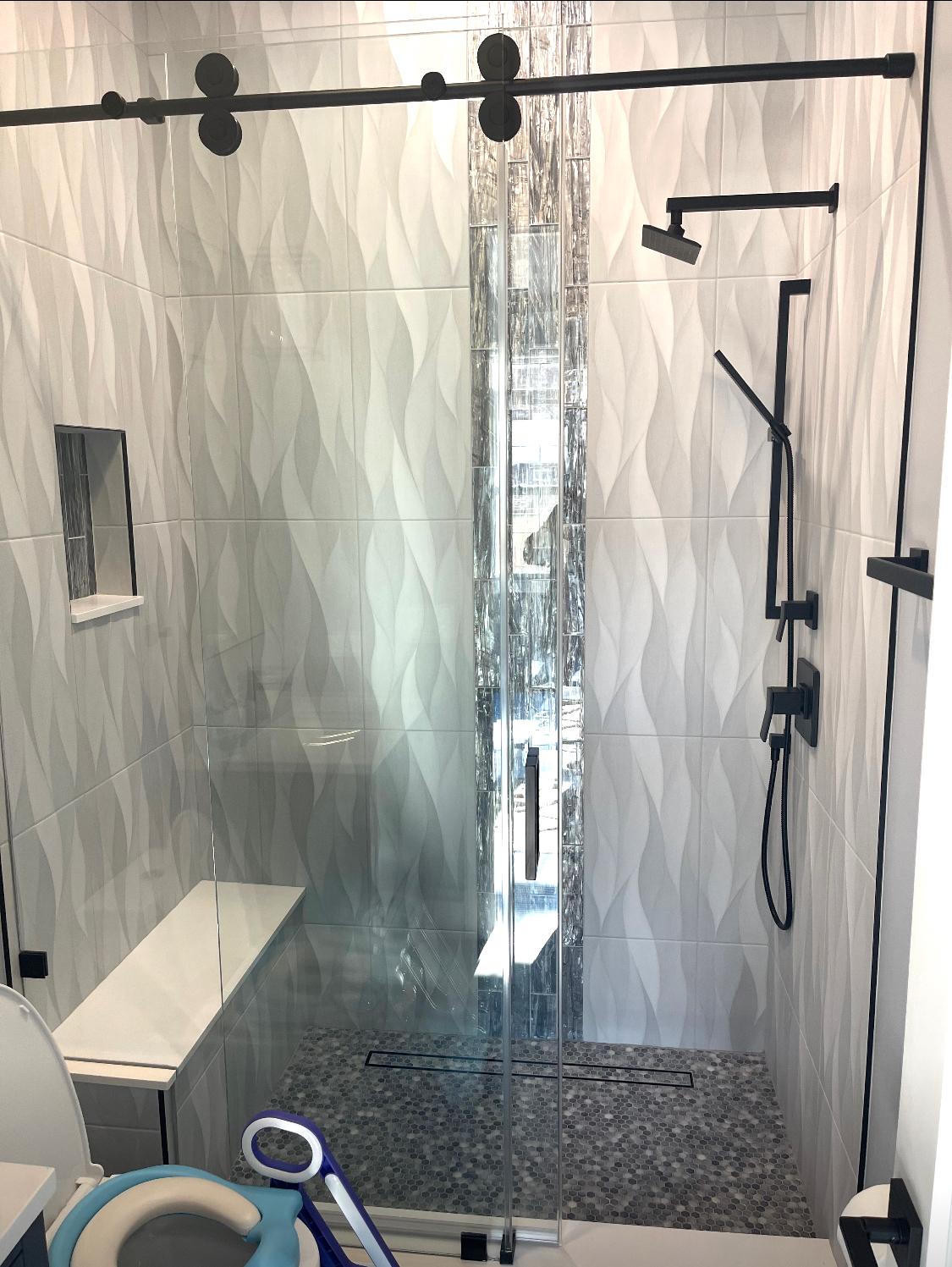 Custom wave-pattern tile shower with frameless glass