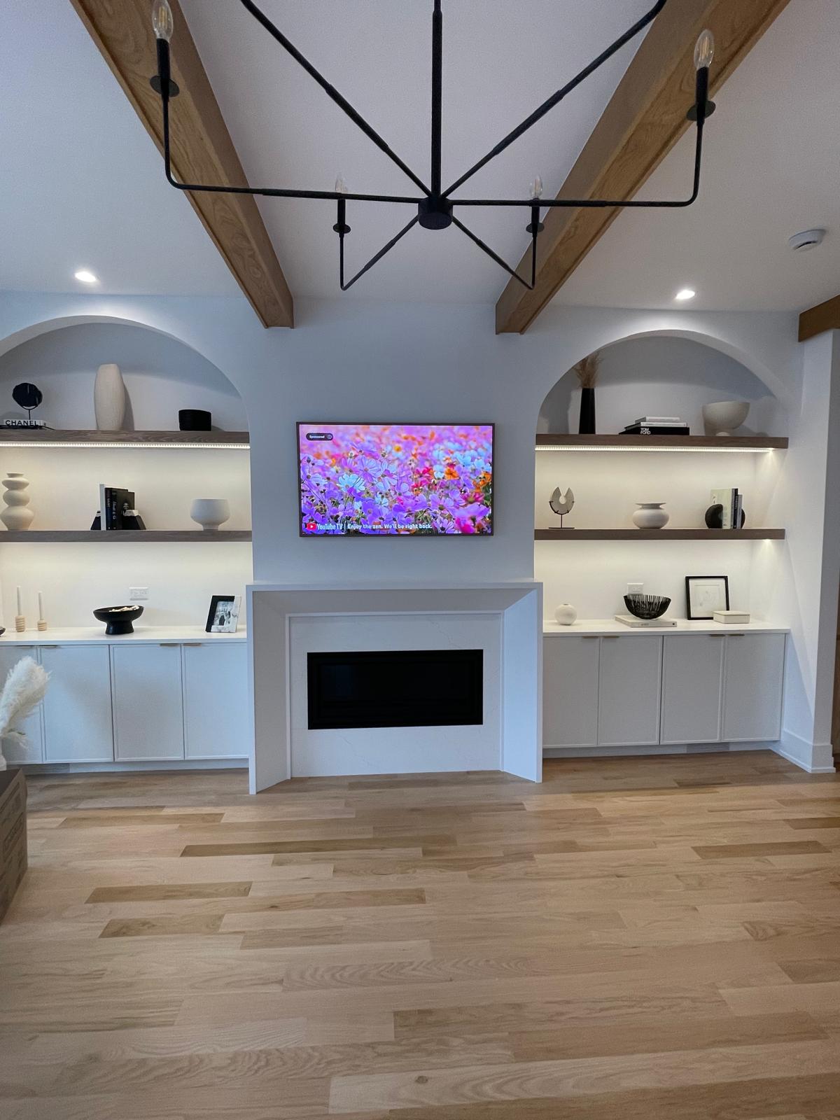 Living room fireplace flanked by arched display niches